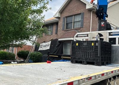 New roof shingles being lifted to second story of home